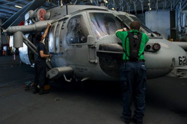 South of Japan, Aviation Structural Mechanic Airman Joseph Tuazon applies alodine to unpainted screws on an MH-60S Sea Hawk assigned to the Helicopter Sea Combat Squadron 12 as Aviation Structural Mechanic 3rd Class Jesse Barlow uses a scribe to remove corrosion from screws on its windshield. The Navy’s new Al-Rich primer is a metalized, chromate-free, anti-corrosion primer designed for nonhazardous use by structural mechanics in charge of corrosion prevention maintenance. Navy photo by Mass Communication Specialist Seaman Jamaal Liddell
